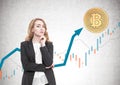 Pensive red haired businesswoman, bitcoin, graph