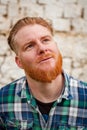 Pensive red haired hipster man with blue plaid shirt