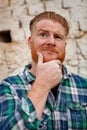 Pensive red haired hipster man with blue plaid shirt