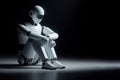 Pensive robot sitting on the floor, on a dark background. Space for text.