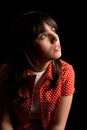 Pensive or sad brunette girl over dark background Royalty Free Stock Photo