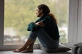 Pensive Latino woman relax at home looking in window Royalty Free Stock Photo