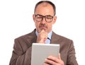 Pensive senior businessman reading on his tablet Royalty Free Stock Photo