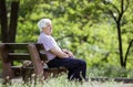 Pensive senior man sitting on bench in park Royalty Free Stock Photo