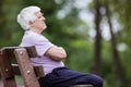 Pensive senior man sitting on bench in park Royalty Free Stock Photo
