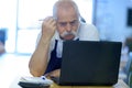 pensive senior man working on laptop