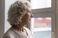 Pensive senior woman looking out the window waiting feels lonely Royalty Free Stock Photo
