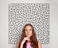 Pensive serious mature brunette woman with labyrinth above her head. Idea, brainstorming, thinking concept