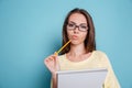 Pensive smart girl thinking about something and holding notebook