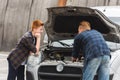 pensive son looking how father repairing car