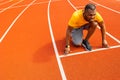 Pensive sporty man getting focused and ready for running training. Afro American runner athlete standing on start line Royalty Free Stock Photo