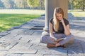 Pensive  student girl is reading a book in autumn park Royalty Free Stock Photo