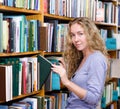 Pensive student in the library surrounded by books Royalty Free Stock Photo