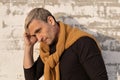 Pensive stylish charming blond middle-aged man of model appearance in front of a white brick wall. Handsome mature male model in Royalty Free Stock Photo