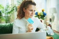 Pensive stylish woman with laptop, credit card and pills