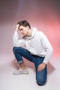 Pensive teen boy posing sitting on the floor in the studio. Portrait of stylishly dressed student. Studio shot Handsome attractive Royalty Free Stock Photo