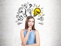 Pensive teen girl in a dress, questions and a bulb Royalty Free Stock Photo