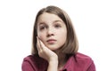 Pensive teenage girl sitting propping her head on her hand. Close-up. Isolated on a white background Royalty Free Stock Photo