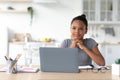 Pensive teenager afro american female, schoolgirl study at home with laptop, pondering on project, prepare to test Royalty Free Stock Photo