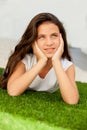 Pensive teenager girl lying on the grass Royalty Free Stock Photo