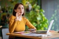 Pensive woman independent contractor working at cafe, using laptop, phone Royalty Free Stock Photo