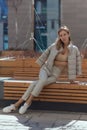 Pensive, thoughtful young woman sitting alone on wooden bench. Sad woman daydreaming, thinking in autumn park. Autumn Royalty Free Stock Photo