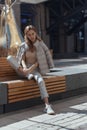 Pensive, thoughtful young woman sitting alone on wooden bench. Sad woman daydreaming, thinking in autumn park. Autumn Royalty Free Stock Photo