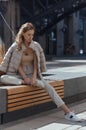 Pensive, thoughtful young woman sitting alone on wooden bench. Sad woman daydreaming, thinking in autumn park. Autumn Royalty Free Stock Photo