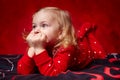 Pensive toddler girl laying in bed with hands on chin Royalty Free Stock Photo