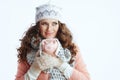 pensive trendy female in sweater, mittens, hat and scarf on