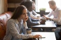 Pensive upset young girl sitting alone at table in cafe