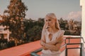 Pensive woman on the balcony. Looking into distance, sad and lonely, waiting for things to be better Royalty Free Stock Photo