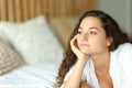 Pensive woman on a bed looking away Royalty Free Stock Photo