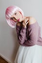 Pensive woman with bright makeup and pink periwig posing on light background. Inspired caucasian female model in soft