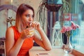 Pensive woman drinking orange juice, looking away Royalty Free Stock Photo