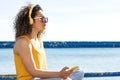 Pensive woman listening to music in headphones against sea Royalty Free Stock Photo