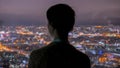 Pensive woman looking at night city from skyscraper Royalty Free Stock Photo