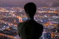Pensive woman looking at night city from skyscraper Royalty Free Stock Photo