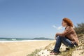 Pensive woman sitting on the dunes Royalty Free Stock Photo