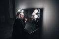 Pensive woman sitting near mirror with bulbs in dressing room Royalty Free Stock Photo