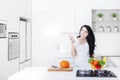 Pensive woman with smartphone in the kitchen Royalty Free Stock Photo