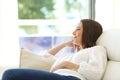 Pensive woman thinking sitting on a couch Royalty Free Stock Photo