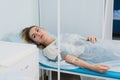 Pensive woman transfused lying in hospital ward