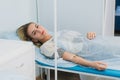 Pensive woman transfused lying in hospital ward