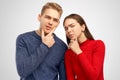 Pensive woman and man coworkers hold chin, look seriously at camera, being deep in thoughts, isolated over white wall in studio Royalty Free Stock Photo