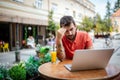 Pensive or worried young business man using laptop at cafe. Royalty Free Stock Photo