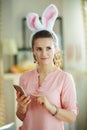 Woman with smartphone in modern house in sunny spring day Royalty Free Stock Photo