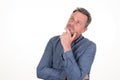 Pensive young bearded man in blue shirt looking up aside copy space posing isolated on white background studio portrait Royalty Free Stock Photo