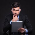 Pensive young business man with tablet Royalty Free Stock Photo