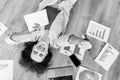 Pensive young business woman sitting on floor at home, using laptop, developing new project. Thoughtful stylish female Royalty Free Stock Photo